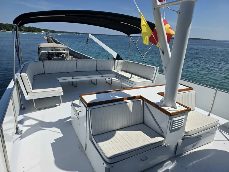 Slide: The Image of The image shows the deck of a 1976 Chris-Craft Roamer 60 with white cushioned seating. - 20