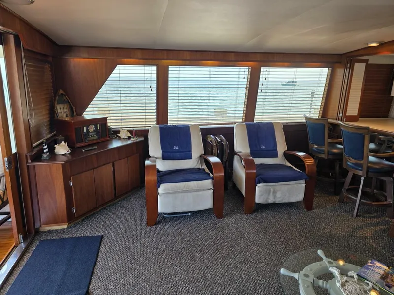 Slide: The Image of Interior of a 1976 Chris-Craft Roamer 60 with comfortable chairs and large windows. - 31