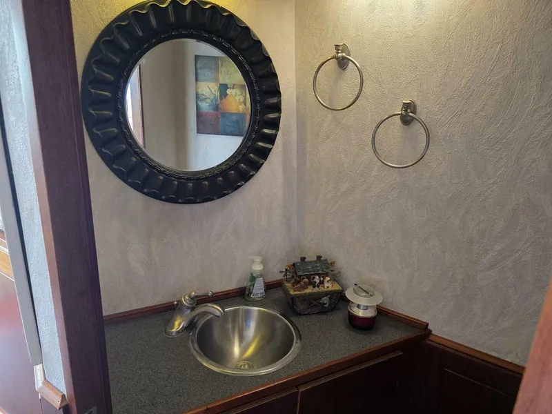 Slide: The Image of An elegant bathroom with a round mirror, sink, and decorative elements. - 25