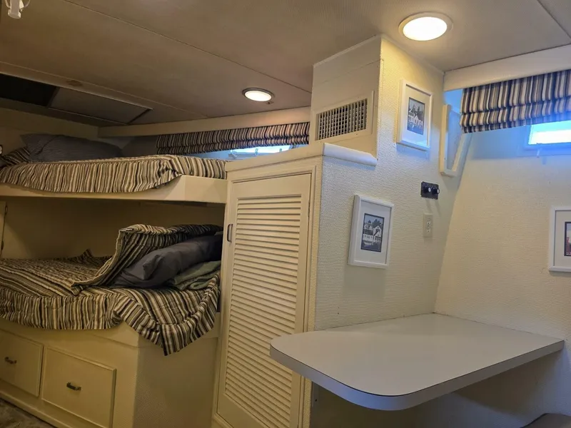Slide: The Image of Interior of a 1976 Chris-Craft Roamer 60 with bunk beds and a small table. - 39
