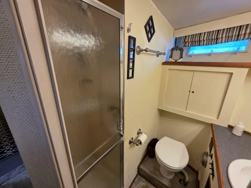 Slide: The Image of The image shows a boat bathroom with a shower, toilet, and sink. - 42