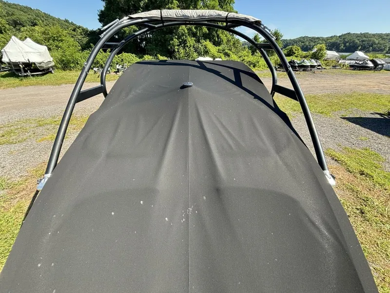 Slide: The Image of A 2013 Yamaha 242 Limited S boat with a black cover, parked on a trailer outdoors. - 38