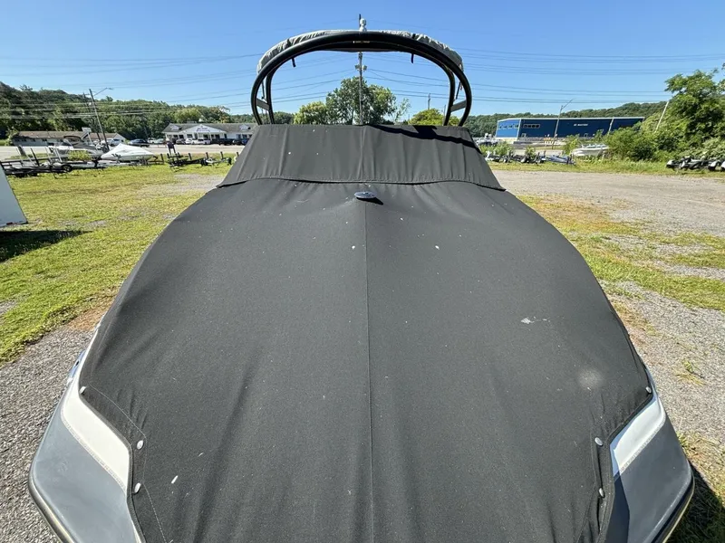Slide: The Image of A 2013 Yamaha 242 Limited S boat with a black cover, parked in a lot. - 37