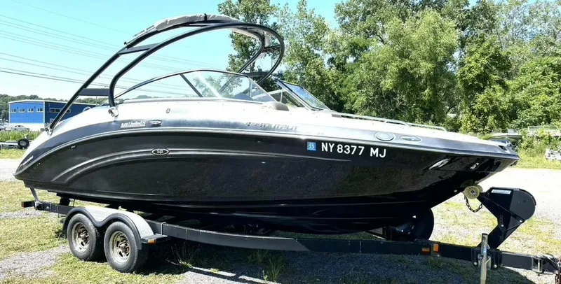 Slide: The Image of A 2013 Yamaha 242 Limited S boat parked on a trailer outdoors. - 7