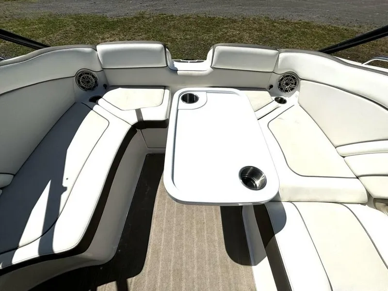 Slide: The Image of Interior view of a 2013 Yamaha 242 Limited S boat with white upholstery and a table. - 16