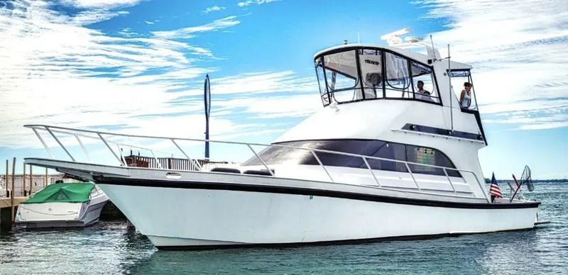 The Image of 1987 Davidson 48 Sportfish on the water, featuring a distinctive superstructure and clear blue sky. - 1