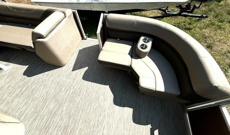 Slide: The Image of The image shows the interior of a Bennington 21 SXSAPG pontoon boat with beige seating and carpeted floor. - 25