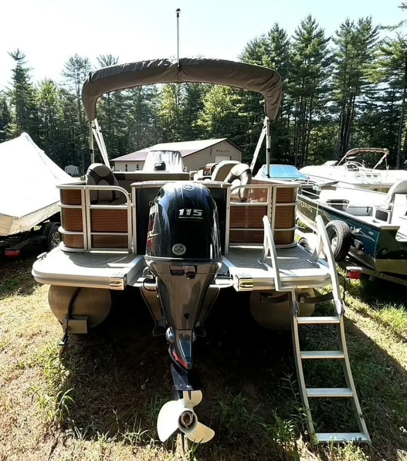 Slide: The Image of A 2023 Bennington 21 SXSAPG pontoon boat with an outboard motor and ladder, surrounded by trees. - 5