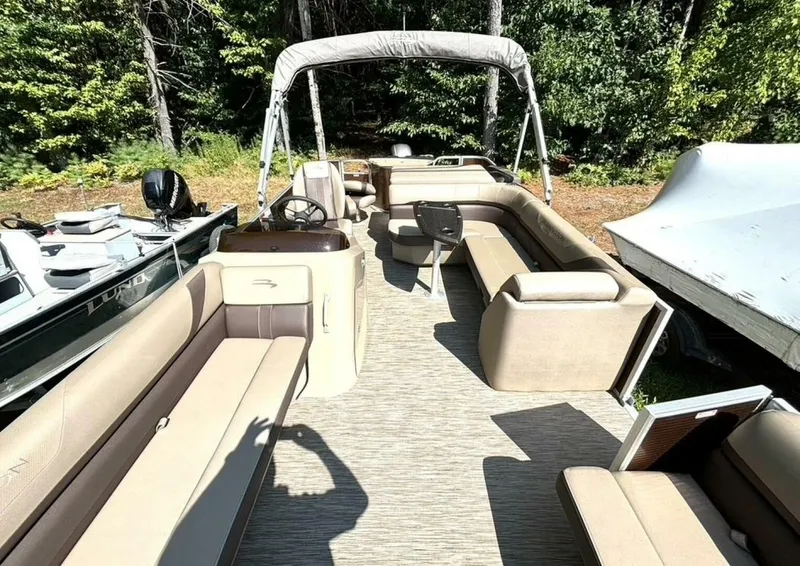 Slide: The Image of The image shows the interior of a 2023 Bennington 21 SXSAPG pontoon boat with beige seating. - 26