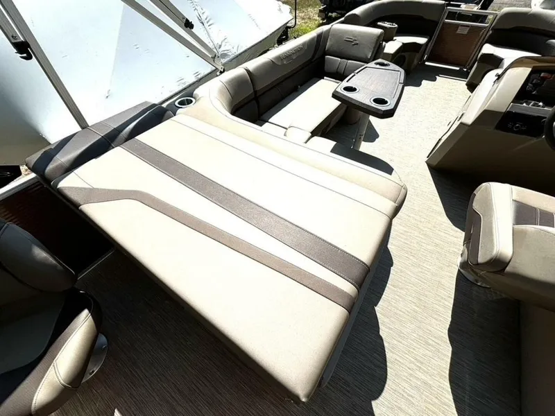 Slide: The Image of Interior of a Bennington 21 SXSAPG pontoon boat with beige upholstery and a table. - 13