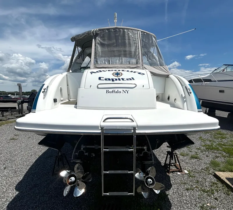 Slide: The Image of Rear view of a white motor yacht with dual propellers, parked on a gravel lot. - 7