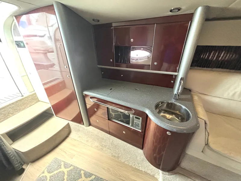 Slide: The Image of The interior cabin of a 2006 Formula 400 Super Sport with sleek wood cabinets and a small kitchenette. - 36