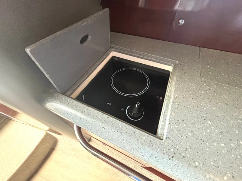 Slide: The Image of A built-in electric stove in a kitchenette with a gray countertop. - 38
