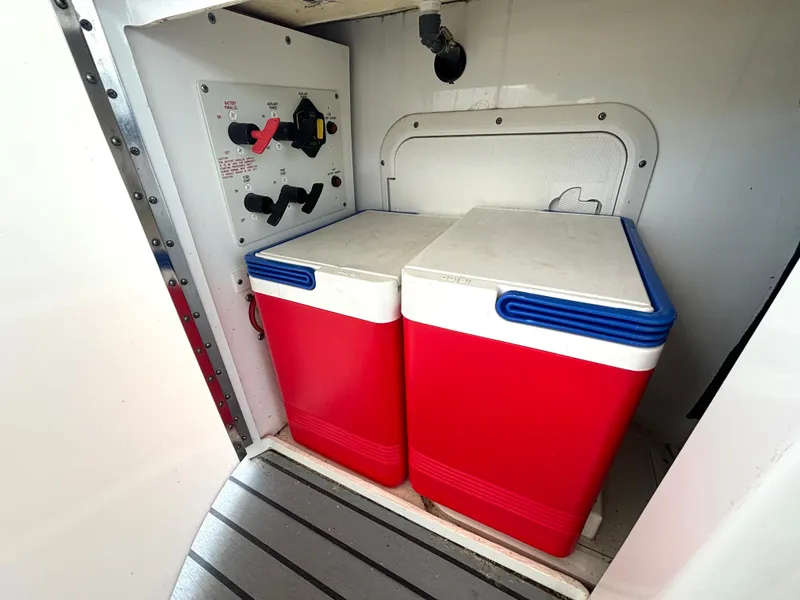 Slide: The Image of Two red coolers sit side by side in a boat storage compartment with a control panel. - 23