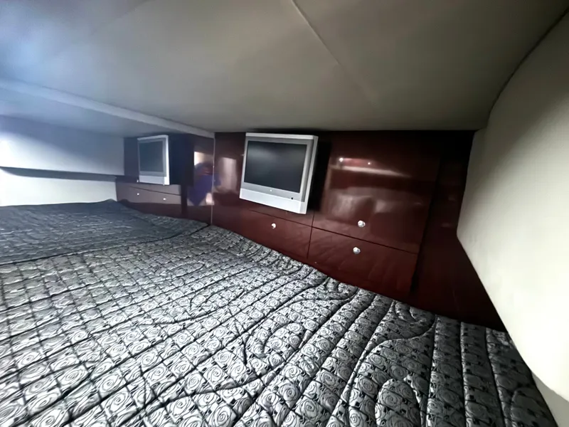 Slide: The Image of The 2006 Formula 400 Super Sport cabin features an elegant bed with patterned cover and a TV. - 46