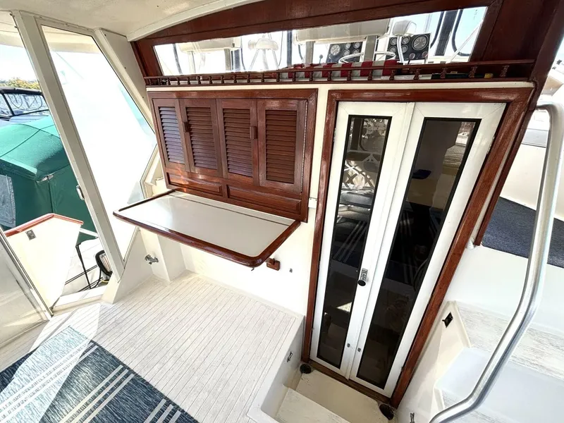 Slide: The Image of Interior of a 1987 Viking Motor Yacht with wooden doors and a fold-down table. - 23