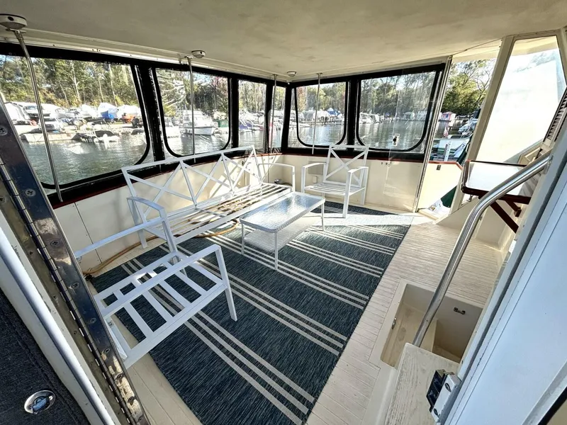 Slide: The Image of The image shows the interior of a 1987 Viking Motor Yacht with white furniture and large windows. - 18