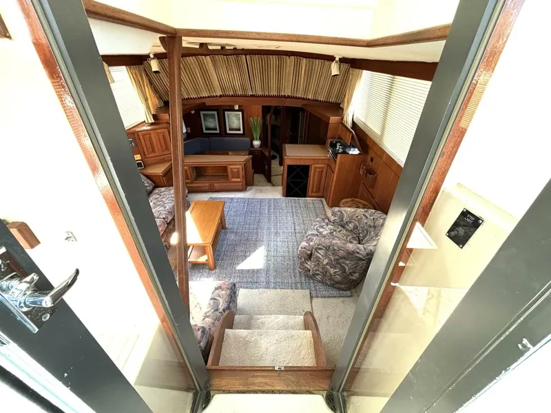 Slide: The Image of Interior of a 1987 Viking Motor Yacht featuring a cozy living area with carpet and wooden furniture. - 40