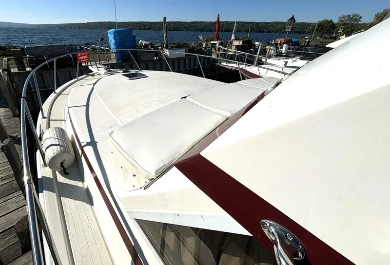 Slide: The Image of A 1987 white motor yacht docked, overlooking a scenic lake. - 9