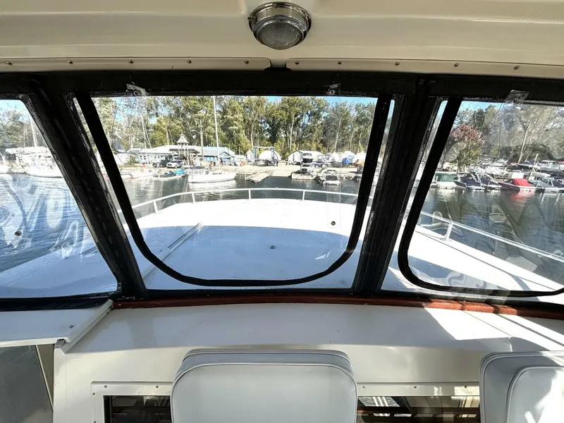 Slide: The Image of View from a yacht's helm looking out at a marina with several boats in the background. - 38
