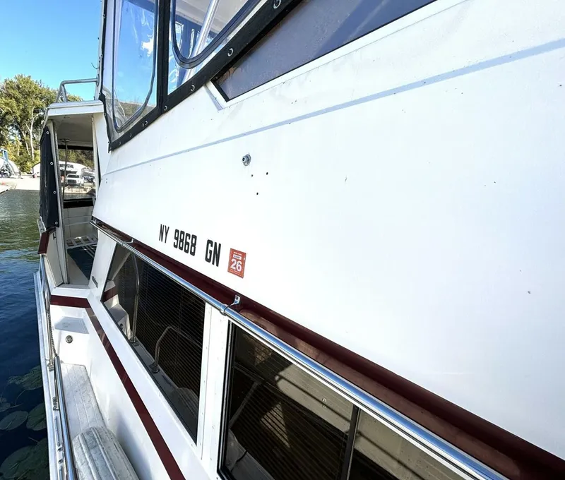 Slide: The Image of Side view of a white yacht with red accents, docked in the water. - 16