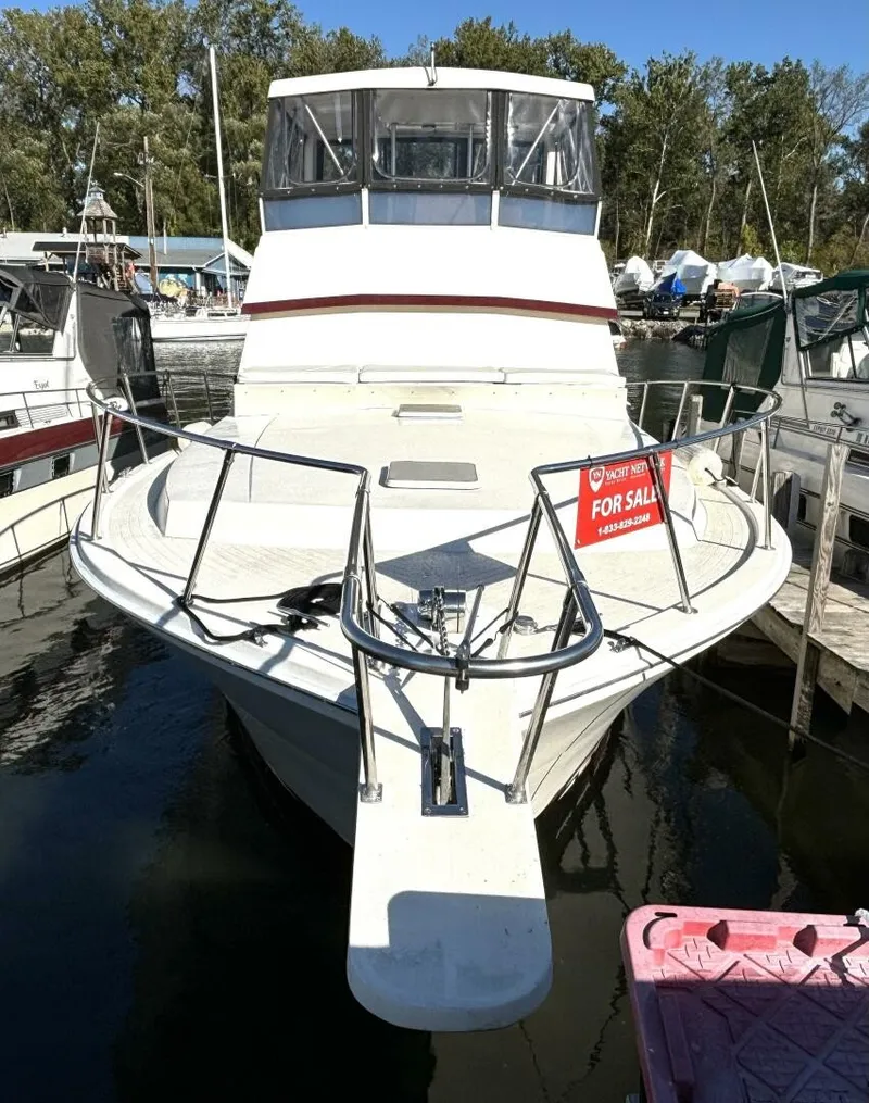Slide: The Image of A 1987 white motor yacht is docked in the water, surrounded by other boats. A "For Sale" sign is visible. - 2