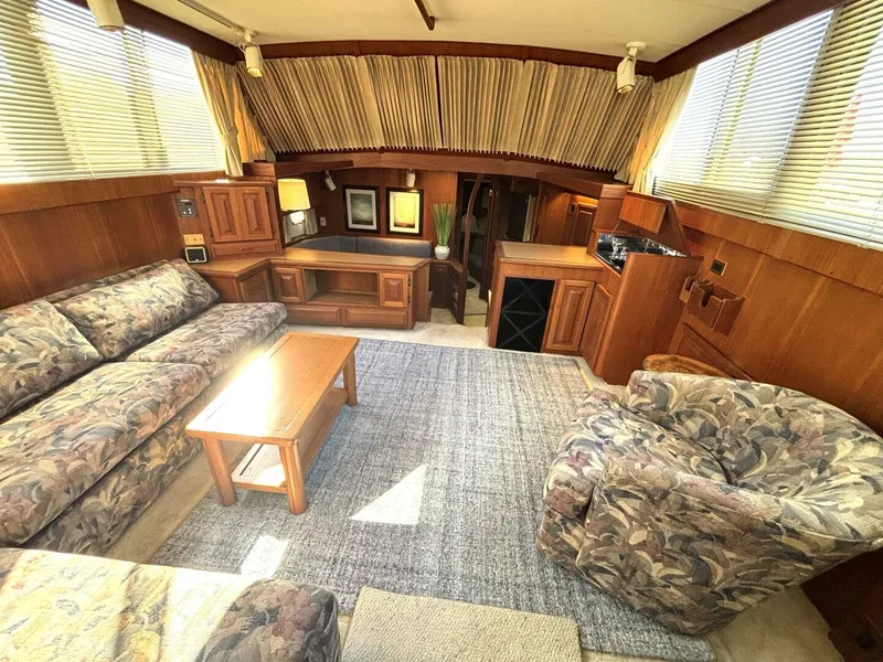 Slide: The Image of Interior of a 1987 Viking Motor Yacht with cozy sofas, carpet, and wooden furnishings. - 41