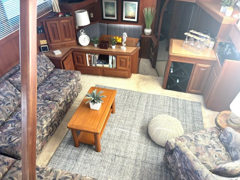 Slide: The Image of Interior of a 1987 Viking Motor Yacht with cozy sofas, wooden furniture, and a rug. - 42