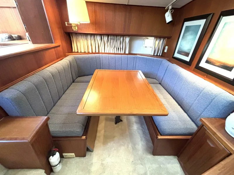 Slide: The Image of Interior of a 1987 Viking Motor Yacht with a cozy seating area and wooden table. - 47