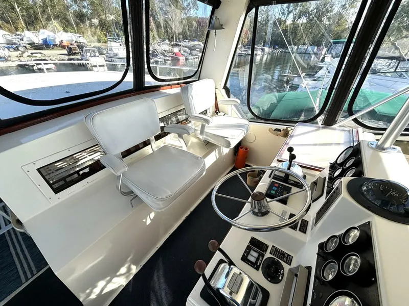 Slide: The Image of Interior of a 1987 Viking Motor Yacht with helm, two white seats, and instrument panel. - 28