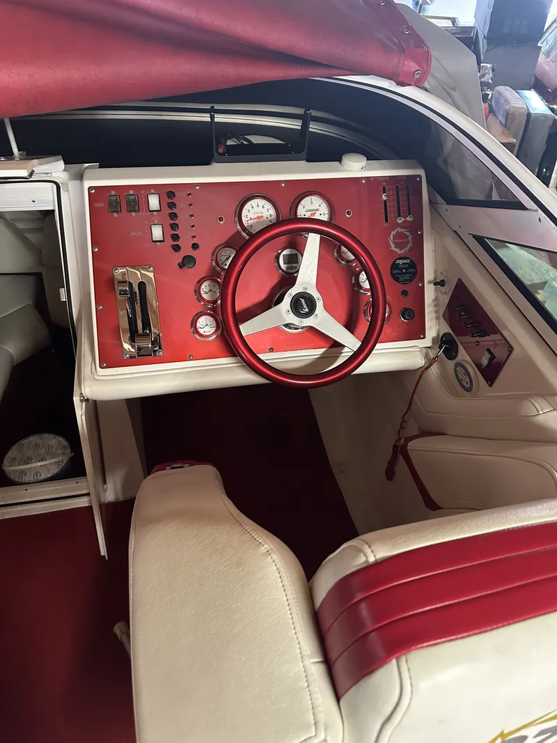 Slide: The Image of The image shows the cockpit of a 2005 Fountain 27 Fever boat with a red steering wheel and dashboard. - 12