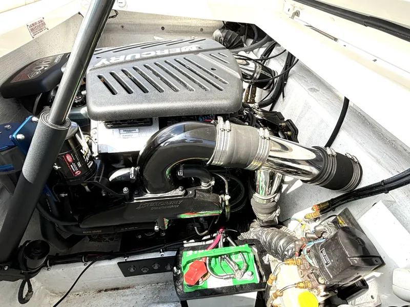 Slide: The Image of The engine compartment of a 2005 Fountain 27 Fever boat features a Mercury engine with shiny components. - 16