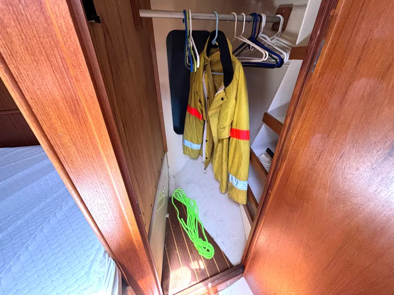 Slide: The Image of A closet in a 1985 Nonsuch 30 Ultra with a yellow jacket and green rope. - 43