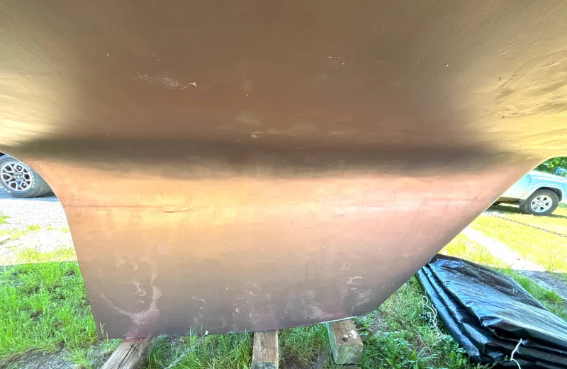 Slide: The Image of Close-up of the hull of a 1985 Nonsuch 30 Ultra, resting on wooden blocks. - 9