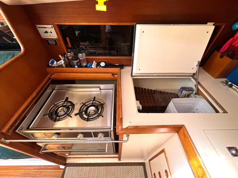 Slide: The Image of The galley of a 1985 Nonsuch 30 Ultra with a two-burner stove and a refrigerator. - 36