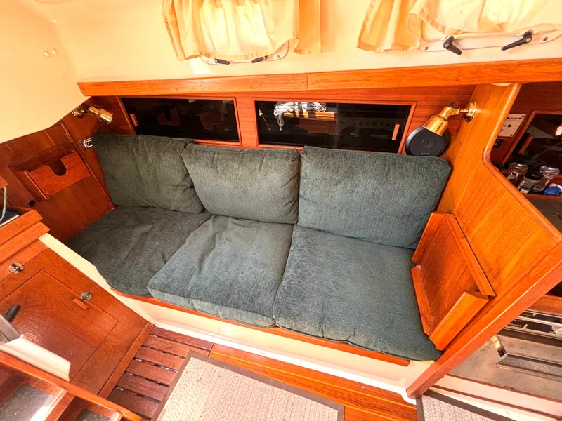 Slide: The Image of Interior of the 1985 Nonsuch 30 Ultra with green cushions on a wooden bench. - 31