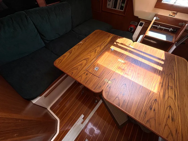 Slide: The Image of Interior of a 1985 Nonsuch 30 Ultra with a wooden table and cushioned seating. - 33