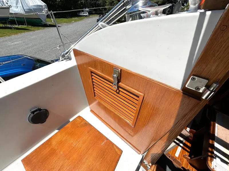 Slide: The Image of Wood-paneled area on a 1985 Nonsuch 30 Ultra, featuring a vented panel and latch. - 20