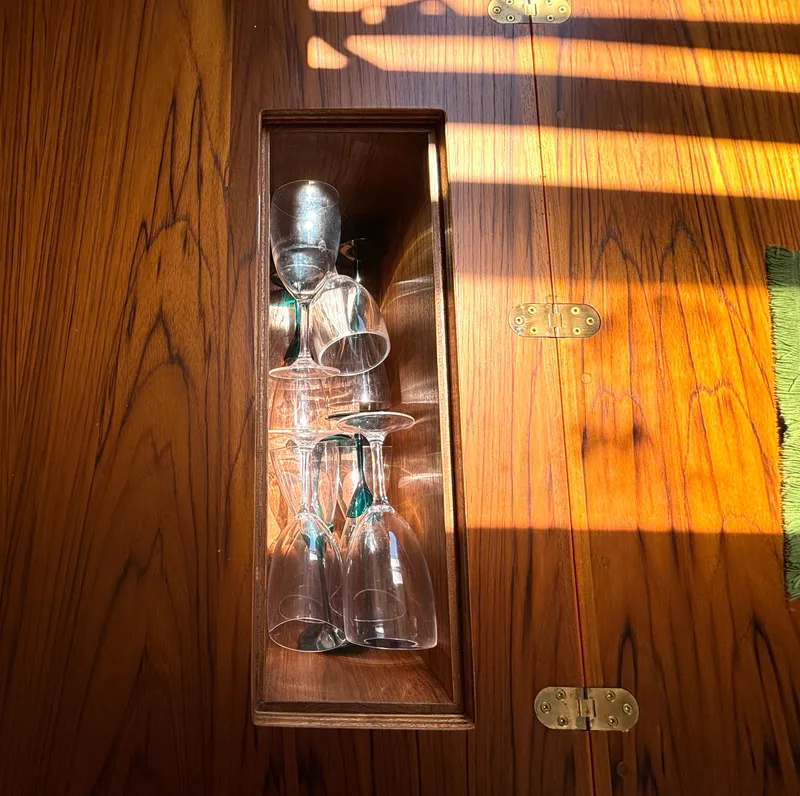 Slide: The Image of A wooden cabinet with glasses inside, illuminated by sunlight. - 34