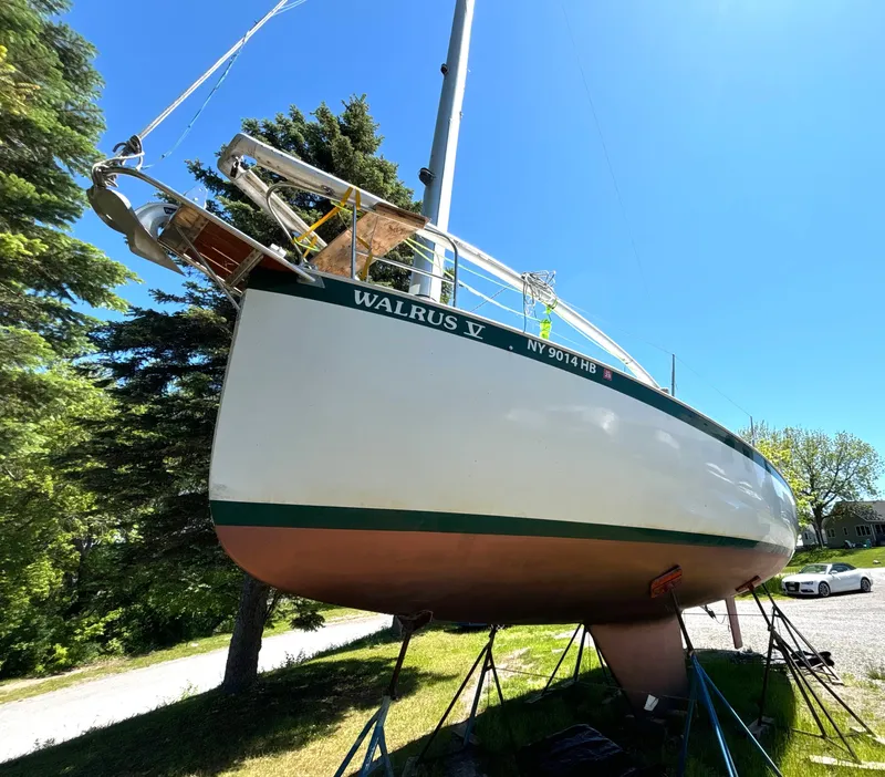Slide: The Image of 1985 Nonsuch 30 Ultra sailboat on a stand, surrounded by trees and blue sky. - 2