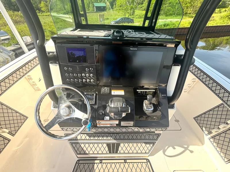 Slide: The Image of The image shows the helm of a 2019 Wellcraft 302 Center Console boat. - 23