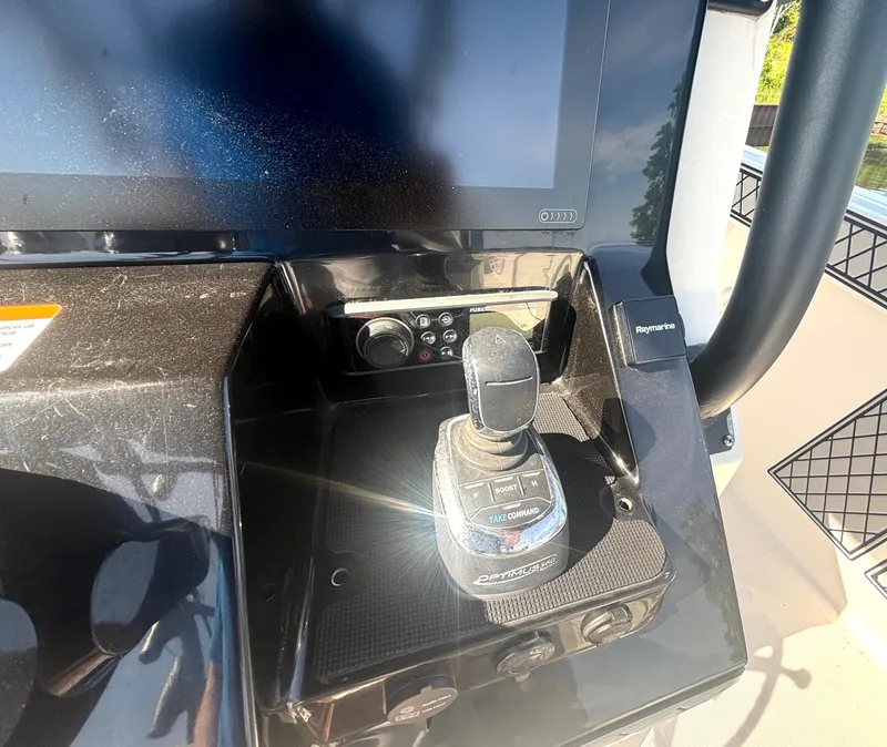 Slide: The Image of The image shows the helm of a 2019 Wellcraft 302 Center Console boat with a joystick. - 25