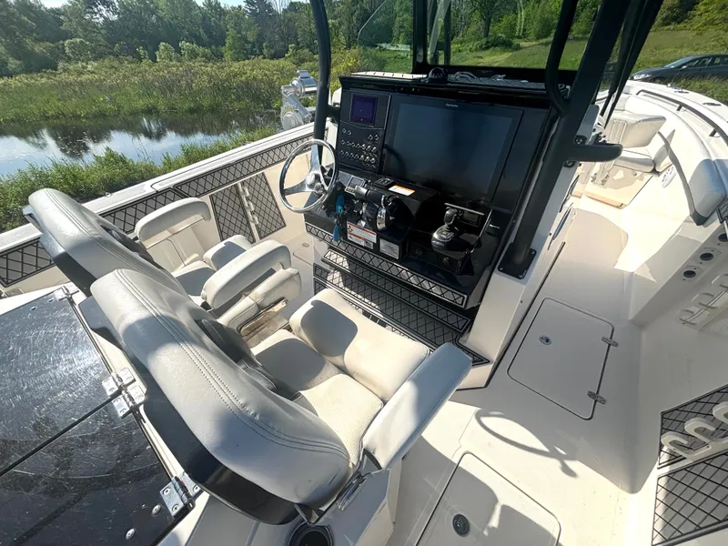 Slide: The Image of The image shows the cockpit of a 2019 Wellcraft 302 Center Console boat with modern instruments. - 22