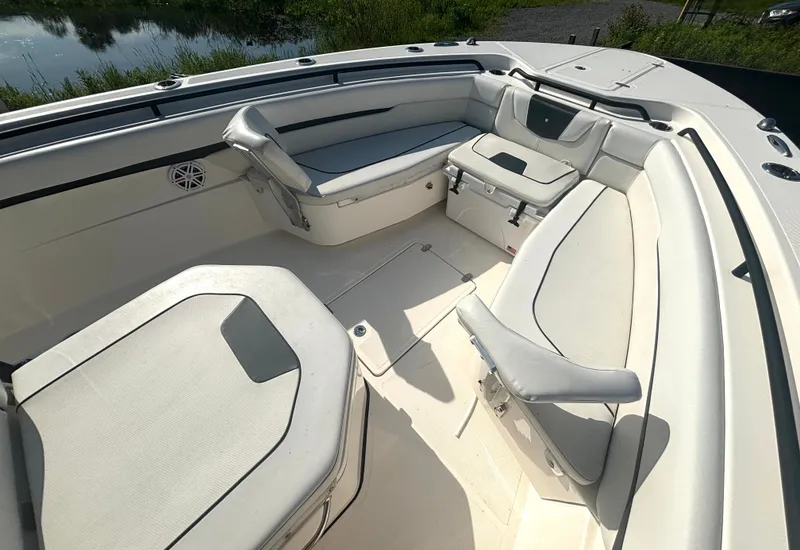 Slide: The Image of The image shows the bow area of a 2019 Wellcraft 302 Center Console boat with white upholstery. - 32