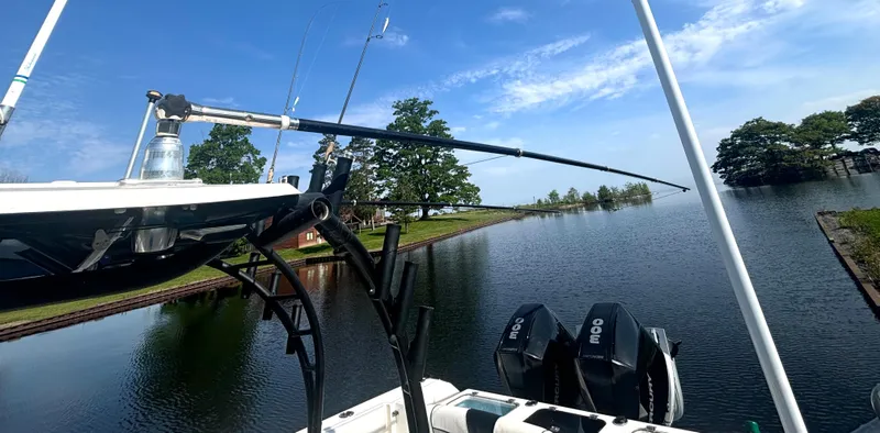 Slide: The Image of A 2019 Wellcraft 302 Center Console boat on a calm river with fishing rods. - 40