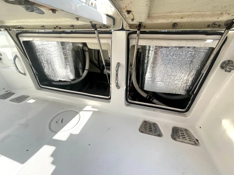 Slide: The Image of A 2019 Wellcraft 302 Center Console with open storage compartments revealing insulated pipes. - 17
