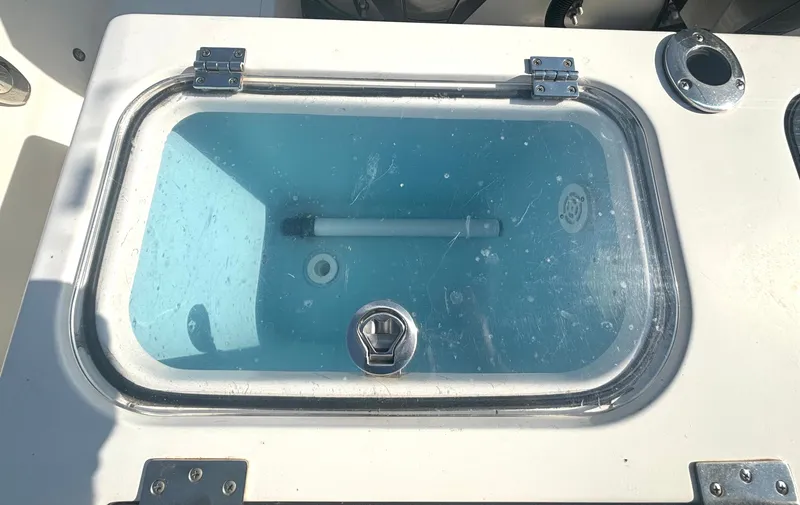 Slide: The Image of A livewell on a 2019 Wellcraft 302 Center Console boat, featuring clear water and a lid. - 18