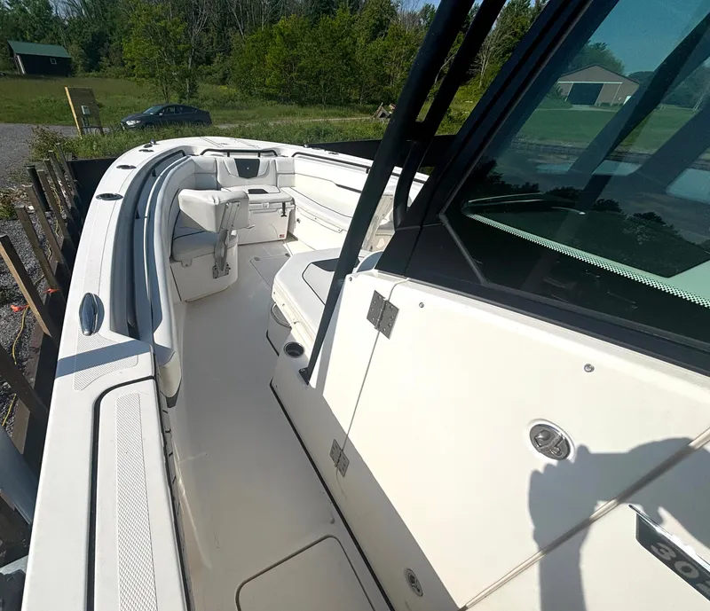 Slide: The Image of The image shows the deck of a 2019 Wellcraft 302 Center Console boat with white seating. - 31