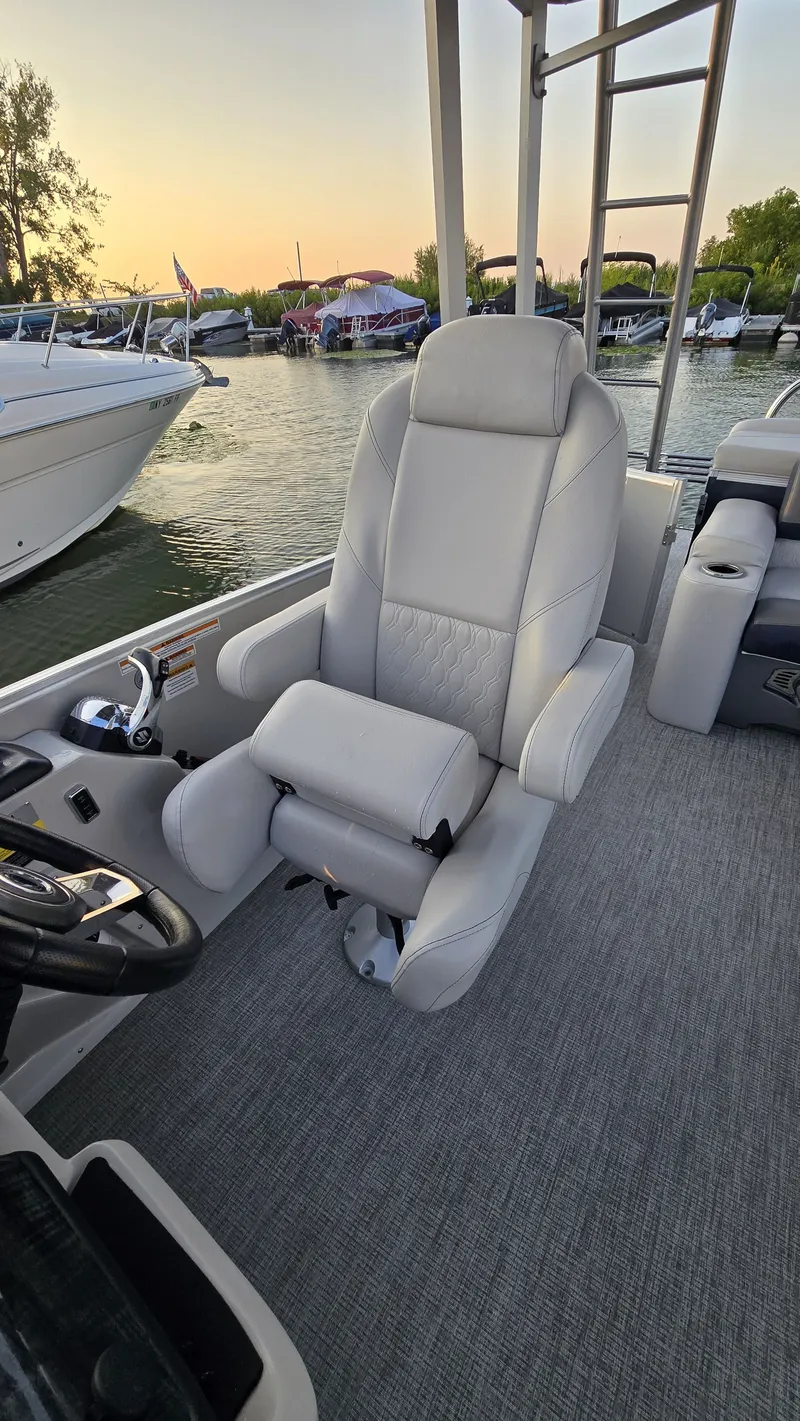 Slide: The Image of The 2023 Avalon Catalina 2585 CRFS Funship features a luxurious captain's chair with gray upholstery. - 7