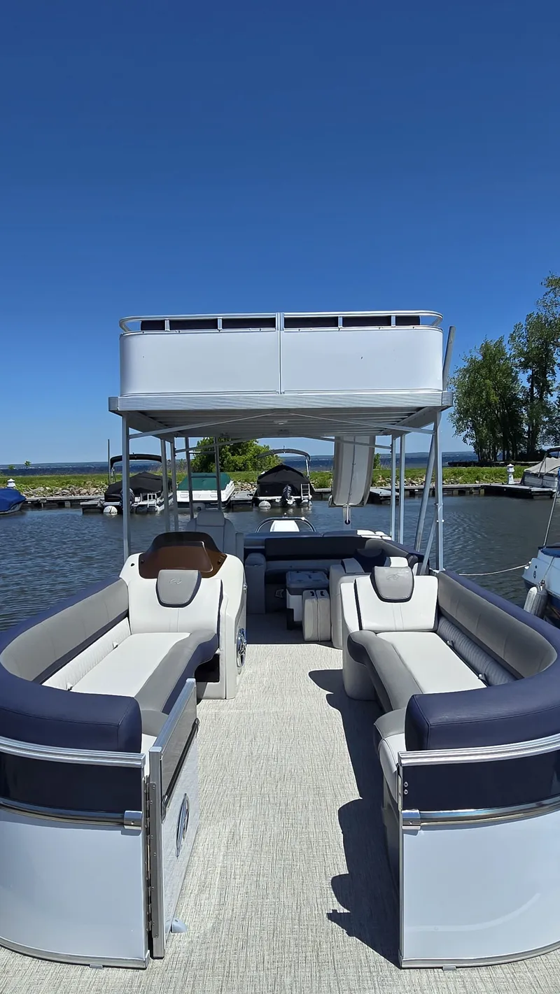 Slide: The Image of 2023 Avalon Catalina 2585 CRFS Funship with spacious deck and seating, on calm water. - 4